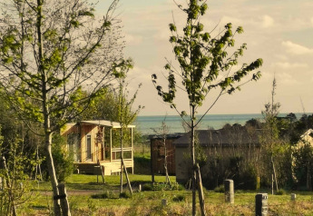 Grüne Landschaft mit Bäumen und Holzhaus bei Cottage at Domaine Seasonova Saâne et Mer in Frankreich.
