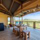 Overdækket terrasse af en safari telt Ecolodge med spisebord, sofa og udsigt over de åbne marker.