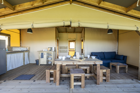 Tente safari Ecolodge au Domaine Seasonova Saâne et Mer en France, avec mobilier en bois et espace ouvert.
