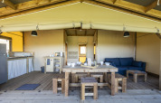Tienda safari Ecolodge en Domaine Seasonova Saâne et Mer, Francia, con muebles de madera y espacio abierto.