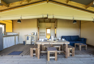 Tienda safari Ecolodge en Domaine Seasonova Saâne et Mer, Francia, con muebles de madera y espacio abierto.