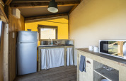 Coin cuisine de la tente safari Ecolodge au Domaine Seasonova Saâne et Mer en France, avec réfrigérateur.