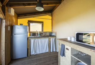 Zona de cocina dentro de la tienda safari Ecolodge en Domaine Seasonova Saâne et Mer, Francia, con nevera.