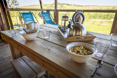 Udendørs morgenmad på træbord med kaffekande og cerealer ved Ecolodge, Domaine Seasonova Saâne et Mer.
