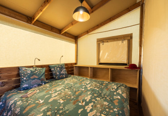 Interiør af et hyggeligt soveværelse i en safari telt Ecolodge på Domaine Seasonova Saâne et Mer i Frankrig.