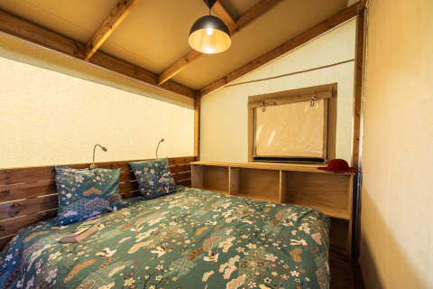 Interiør af et hyggeligt soveværelse i en safari telt Ecolodge på Domaine Seasonova Saâne et Mer i Frankrig.