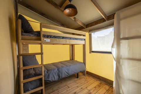 Vista interior de una tienda safari Ecolodge en Domaine Seasonova Saâne et Mer con literas en Francia.