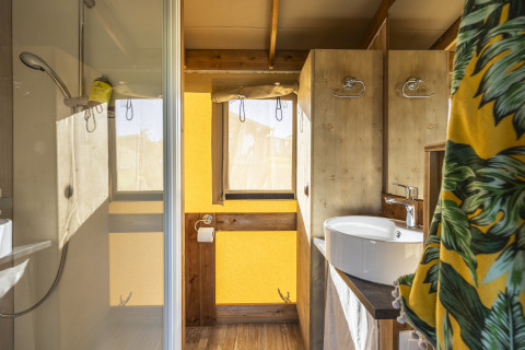 Badeværelse i en safari telt Ecolodge på Domaine Seasonova Saâne et Mer, med bruser, vask og træinteriør.