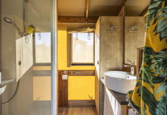 Badeværelse i en safari telt Ecolodge på Domaine Seasonova Saâne et Mer, med bruser, vask og træinteriør.