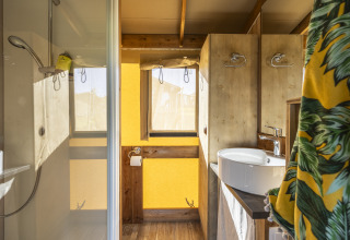 Baño en tienda safari Ecolodge en Domaine Seasonova Saâne et Mer, con ducha, lavabo y detalles en madera.