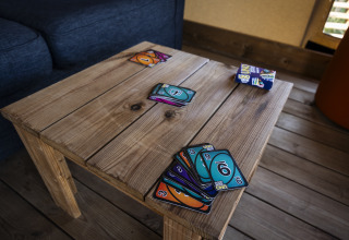 Cartas de UNO en una mesa de madera dentro de una tienda safari en Domaine Seasonova Saâne et Mer, Francia.