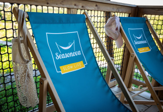 Chaises longues bleues du safari Ecolodge au Domaine Seasonova Saâne et Mer en France, avec filet et casquette.
