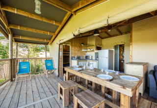 Interiør af en safari-telt ecolodge på Domaine Seasonova Saâne et Mer, med træmøbler og tekøkken.