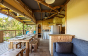 Interior de tienda safari ecolodge con muebles de madera en Domaine Seasonova Saâne et Mer, Francia.