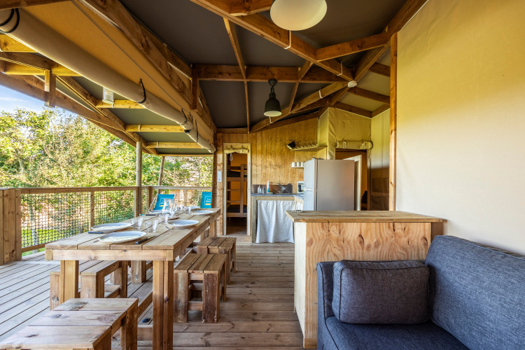 Interior de tienda safari ecolodge con muebles de madera en Domaine Seasonova Saâne et Mer, Francia.