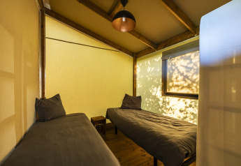 Interieur van een safaritent bij Ecolodge Domaine Seasonova Saâne et Mer in Frankrijk met twee bedden.