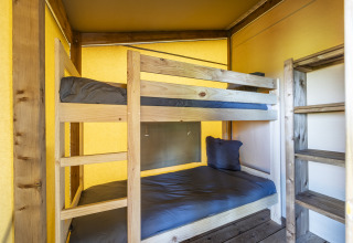 Inde i en safari-telt Ecolodge på Domaine Seasonova Saâne et Mer, Frankrig, med køjesenge i træ.