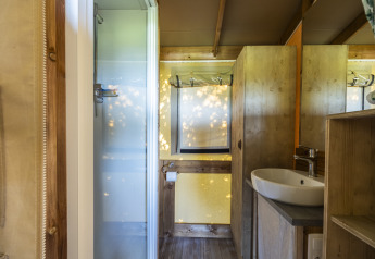 Vue intérieure de la salle de bain dans une tente safari ecolodge au Domaine Seasonova Saâne et Mer en France.