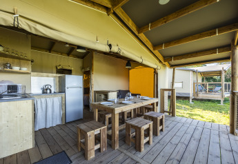 Indretning af en safari-økohytte med køkken, spisebord og terrasse ved Domaine Seasonova Saâne et Mer, Frankrig.