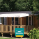 Et hyggeligt træhus ved navn Cottage Zen med veranda, omgivet af grønt ved Campings Seasonova.