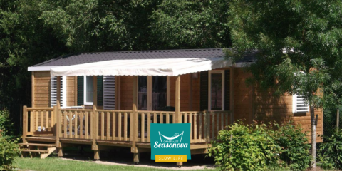 Gemütliches Cottage Zen aus Holz mit Veranda im Grünen, aufgenommen bei Campings Seasonova.