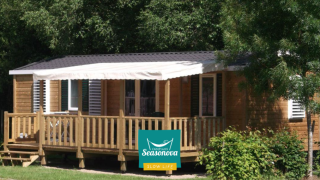 Knus houten huisje Cottage Zen met veranda, omgeven door groen bij Campings Seasonova.