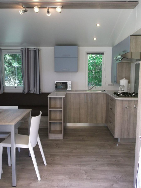 Moderne Küchen- und Essbereich in einer Cottage Zen-Hütte im Camping Seasonova La Forêt in Frankreich.