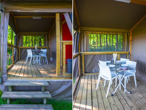 Lichte houten veranda van een safari-tent Mobilodge bij Camping Seasonova La Forêt in Frankrijk met eetgedeelte.