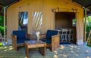 Safari tent Slow Lodge bij Camping Seasonova La Forêt in Frankrijk, houten terras en gezellige zithoek buiten.