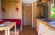 Innenansicht der Gipsy Wagon-Hütte auf Camping Seasonova La Forêt in Frankreich mit Küche und Essbereich.