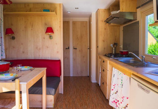 Innenansicht der Gipsy Wagon-Hütte auf Camping Seasonova La Forêt in Frankreich mit Küche und Essbereich.