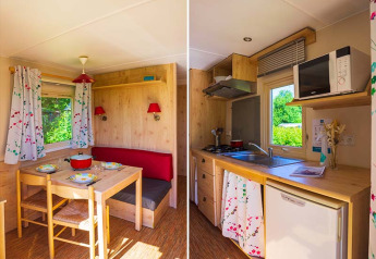 Knus interieur in de Gipsy wagon bij Camping Seasonova La Forêt, Frankrijk, met eet- en keukenruimte.
