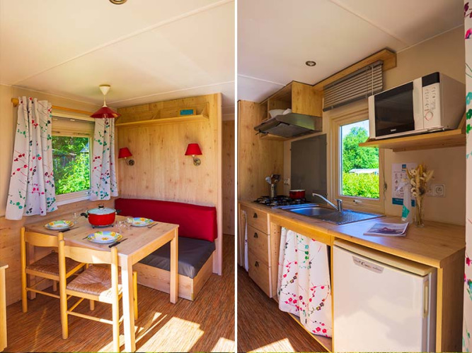 Acogedor interior de la cabaña Gipsy wagon en Camping Seasonova La Forêt, Francia, con comedor y cocina.