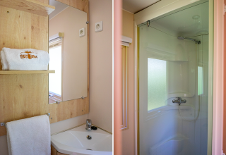 Baño en la Gipsy wagon en Camping Seasonova La Forêt, Francia, con lavabo, espejo y ducha moderna.