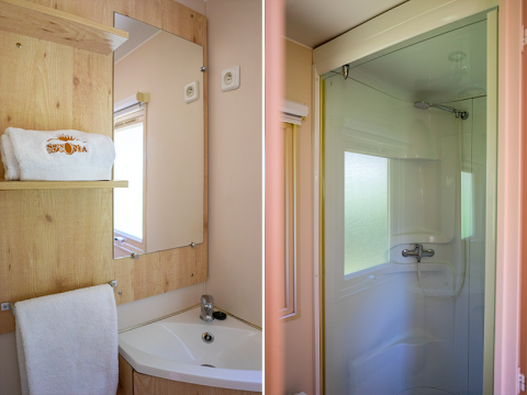 Badezimmer im Gipsy wagon auf dem Campingplatz Seasonova La Forêt in Frankreich mit Waschbecken und Dusche.