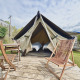 Glamping indkvartering med telt, to enkeltsenge, træmøbler og terrasse i naturskønne omgivelser.