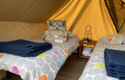 Interior de una tienda tipi Nomad Bivouac con dos camas en Camping Seasonova Le Point du Jour, Francia.