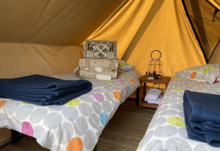 Interior de una tienda tipi Nomad Bivouac con dos camas en Camping Seasonova Le Point du Jour, Francia.