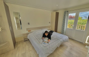 Person reading a magazine on a bed in an accessible cabin at Camping Seasonova Le Point du Jour in France.