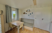 Acogedora sala de estar en Cottage Zen de Camping Seasonova Le Point du Jour, Francia, con mesa y sofá modernos.