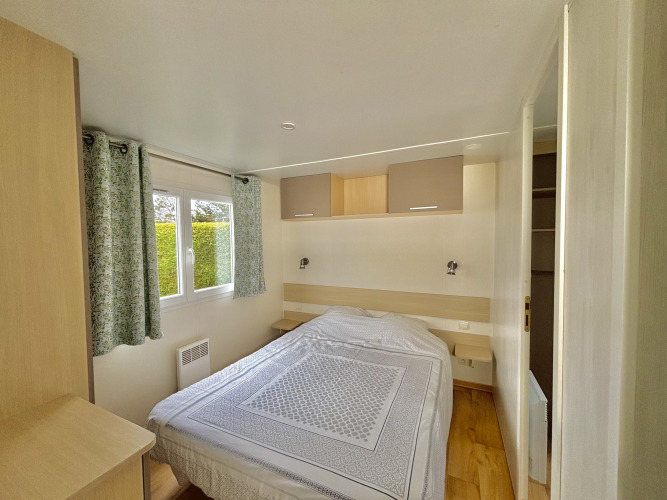 Schlafzimmer im Cottage Zen auf Camping Seasonova Le Point du Jour in Frankreich mit Doppelbett.