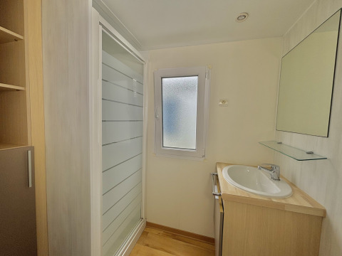 Baño con ducha, lavabo, espejo y ventana en Cottage Zen en Camping Seasonova Le Point du Jour en Francia.
