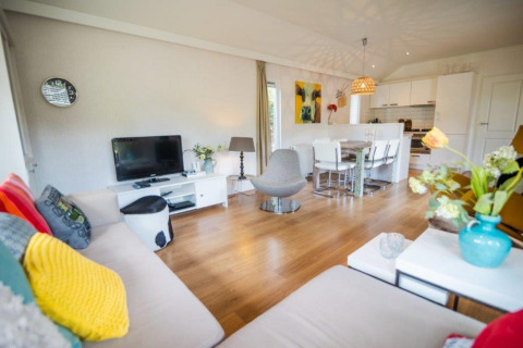 Modernes, helles Wohnzimmer im Nature Chalet im Bospark Markelo, Niederlande, mit offener Küche und Einrichtung.