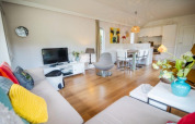 Lyst og moderne opholdsrum i Nature Chalet på Bospark Markelo, Holland, med åbent køkken og farverige detaljer.
