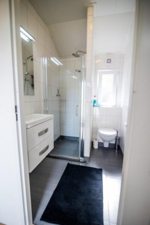 Baño moderno con ducha, lavabo y WC en Nature Chalet en Bospark Markelo, Países Bajos.