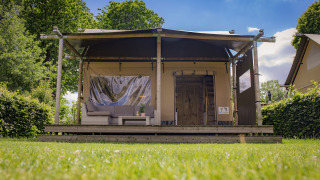 Luxuriöse Safari-Lodge im Ferienpark De Boshoek in den Niederlanden, umgeben von grüner Natur.