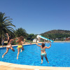 Three women jump into the pool at Camping Mas Patoxas, a holiday park in Catalonia, Spain on a sunny day.