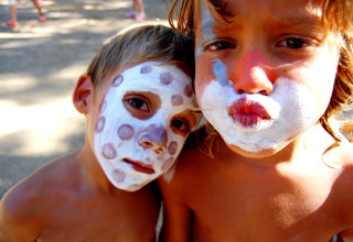 Twee kinderen met geschminkt gezicht op Camping Mas Patoxas, een vakantiepark in Catalonië, Spanje.