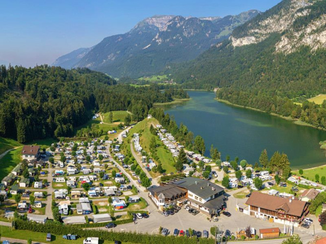 Campingplatz Seeblick Toni in Tirol, Österreich, mit Blick auf einen See, Berge und viele Stellplätze.