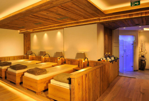 Sala de relajación con tumbonas de madera y iluminación cálida en Camping Seeblick Toni, Tirol, Austria.